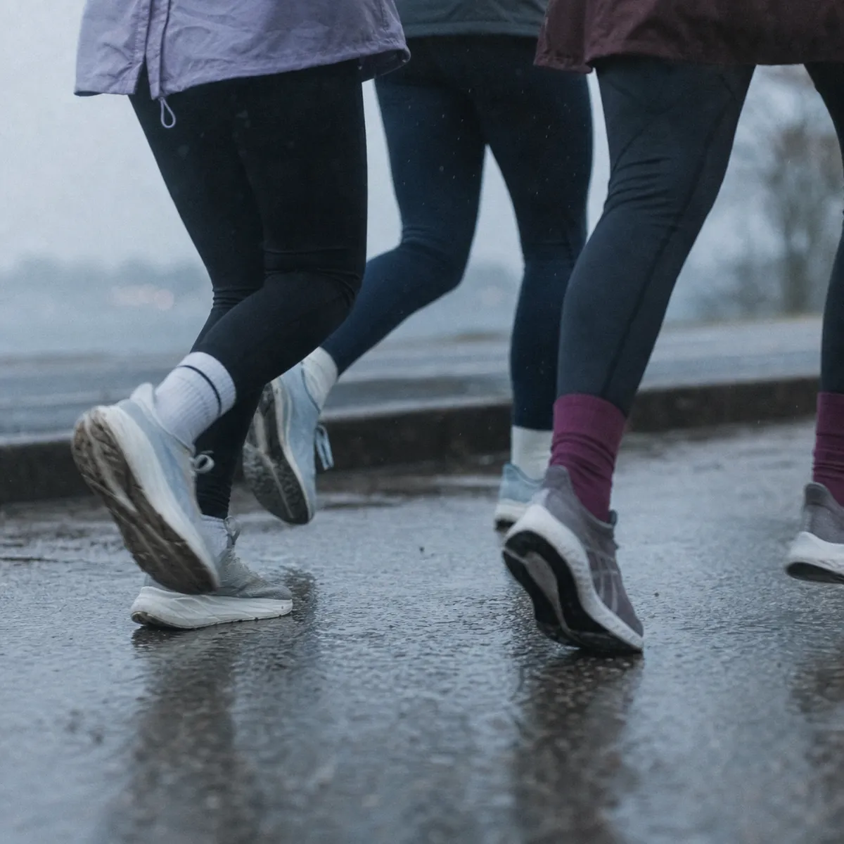 Running shoes moving together across wet pavement